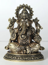 Small brass Ganesha statue, four arms holding laddu, seated on ornate base