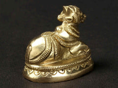 Small Nandi brass idol, front-left view with raised head and patterned body
