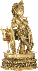 Krishna brass sculpture playing flute with cow at his side, detailed crown and clothing