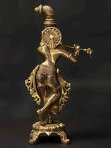 Brass Krishna playing flute figurine with detailed engravings, on decorative chowki