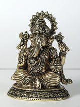 Brass Ganesha statue with four arms, laddu held, ornate jewelry, seated