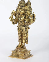 Brass Trimurti idol, side view with raised hands and carved headdress