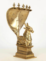 Brass Nandi seated on base with five-headed Sheshnag canopy, 29 cm