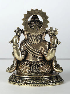 Brass Ganesha statue, four arms holding laddu, seated, ornate halo and base