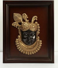 Brass Shrinath Ji face wall hanging in dark wooden frame, ornate crown details