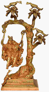 Brass Radha-Krishna statue on swing atop ornate tree base, 16 inches