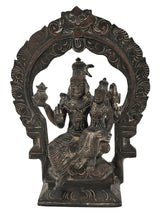 Antique brass Shiva-Parvati idol seated on ornate kirtimukha throne, hands raised