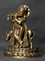 Brass Kanhaiya idol holding a flute, ornate jewelry and draped garment on base