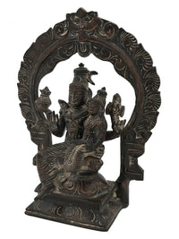 Brass Shiva and Parvati idol with halo-style kirtimukha arch, seated on pedestal