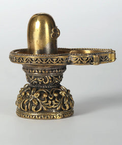 Small brass Shiva linga idol with ornate floral base, 2 inches