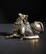 Small decorated Nandi idol in brass and stone, seated with ornate saddle and ornaments