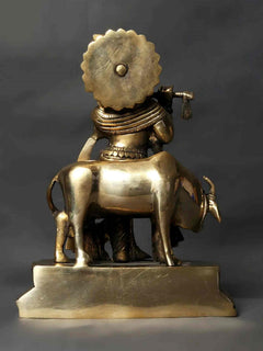 Brass Kanhaiya idol rear view, flute raised, bull at feet with raised base