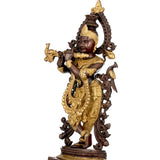Krishna brass sculpture in gold and dark brown, flute pose, side view of ornate halo