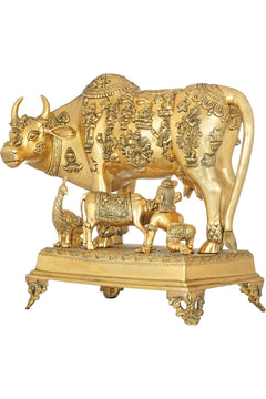 Brass cow sculpture with carved figures on body and pedestal, 20 inches tall