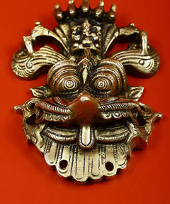 Kirtimukha wall plaque, central face and scroll ornaments with small top figure detail