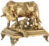 Brass cow sculpture on carved pedestal, front view with horn and detailed figures