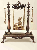 Brass swing stand with seated Butter Krishna figurine, chains and bells, 16 inches