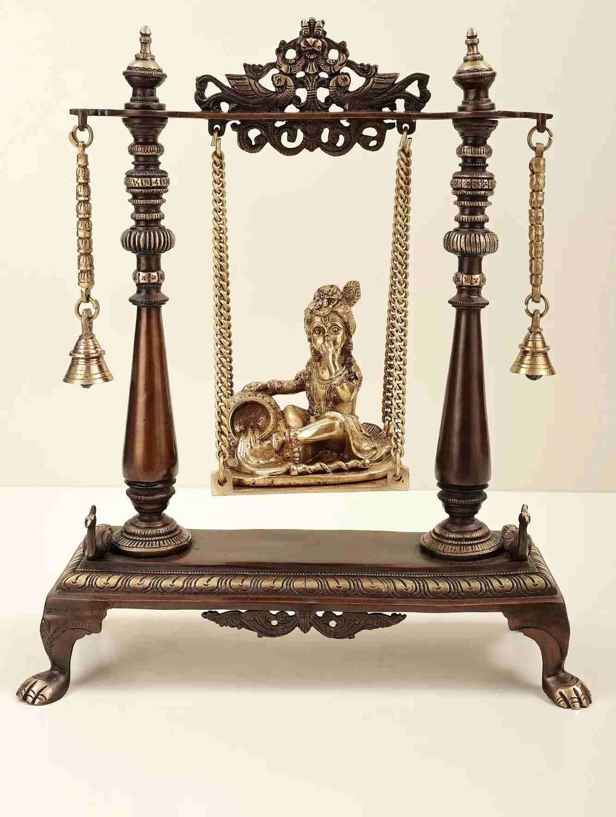 Brass swing stand with seated Butter Krishna figurine, chains and bells, 16 inches