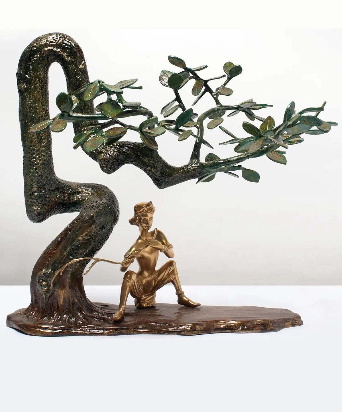19-inch brass Krishna flute statue under tree with sculpted green-leaf branches