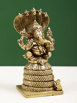 Brass Ganesha statue with four raised arms, seated on five-hooded serpent base, 4 in