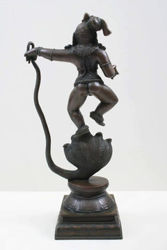 Antique brass Lord Krishna statue defeating Kaliya, side view on cobra base