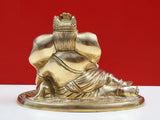 Brass Ganesha idol side view, modak near lap, seated on round decorative pedestal