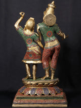 Radha and Krishna dancing figurine, detailed headpieces and patterned garments, carved base