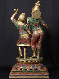 Radha and Krishna dancing figurine, detailed headpieces and patterned garments, carved base