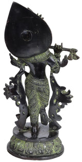 Brass Krishna figurine playing flute, side view with crown and green-gold details