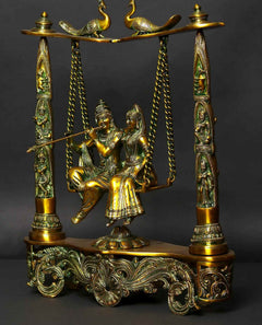 Greenish gold brass Radha Krishna figure on peacock swing, detailed base and pillars