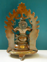 Brass Ganesha statue with arch back and kirtimukha design, 11-inch
