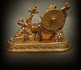 Brass Ganesha statue in relaxed blessing pose, decorative shield and seated form