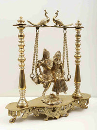 Brass Radha and Krishna on swing, ornate peacock-perched support with chains