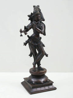 Standing Lord Krishna brass-look statue playing flute, side view, ornate costume and pedestal base