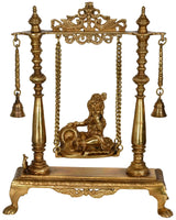 Brass Krishna swing idol on ornate base, suspended by chains with hanging bells
