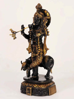 Black and gold brass Venugopal statue, flute held while standing on cow