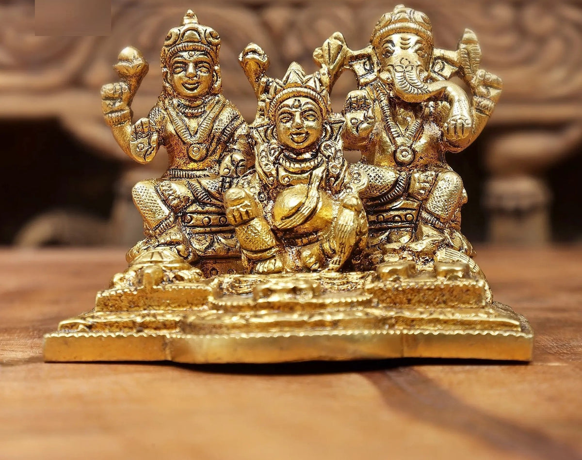 Brass Lakshmi, Ganesha and Kubera statue with raised arms, seated on ornate base