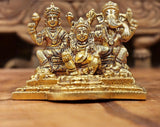 Brass Lakshmi, Ganesha and Kubera statue with raised arms, seated on ornate base