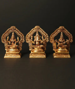 Brass trio of Lakshmi, Ganesha, and Saraswati statues on pedestals