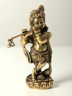 Small brass idol of Bal Krishna playing flute, standing with detailed face and jewelry