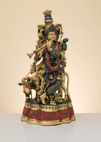 Krishna playing flute brass sculpture with cow, gold finish and red teal detailing