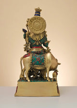 Rear view brass Krishna flute statue with cow, teal and red painted motifs