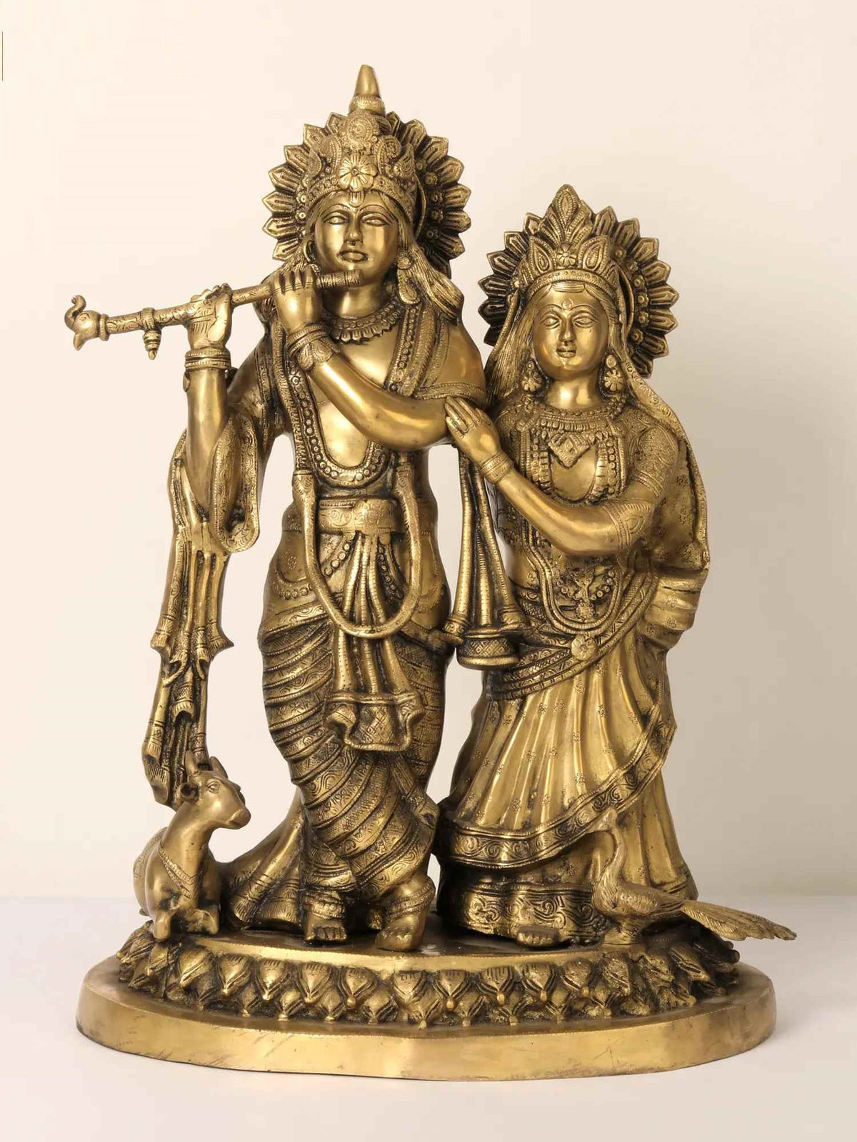 Brass Radha and Krishna statue with flute, cow at feet, peacock-style detailing, 22 inch