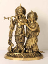 Brass Radha and Krishna statue with flute, cow at feet, peacock-style detailing, 22 inch