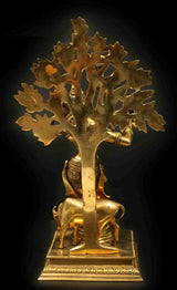 Brass Krishna statue on square base, tribhanga flute pose with large leaf tree