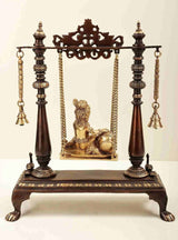 Butter Krishna brass swing display with seated deity, gold chains, twin bell accents