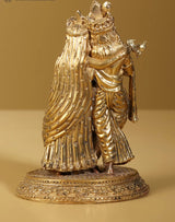Gold brass Radha Krishna statue side view, flowing robes, ornate crowns, pedestal base