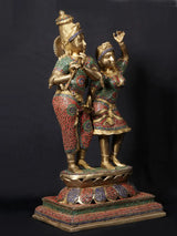 Krishna playing flute with Radha, raised arms, ornate patterned outfits, stonework base