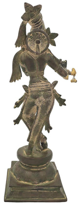 Antique green brass Krishna statue, three-quarter view, playing flute with detailed dress