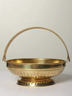Brass pooja flowers basket with arched handle, shallow bowl and decorative base.